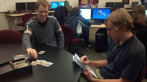 Two people sitting at a table talking, giving feedback, and iterating.